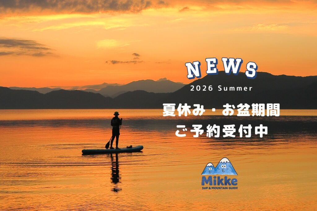 夕日に染まる田沢湖でサンセットSUPを楽しむ様子