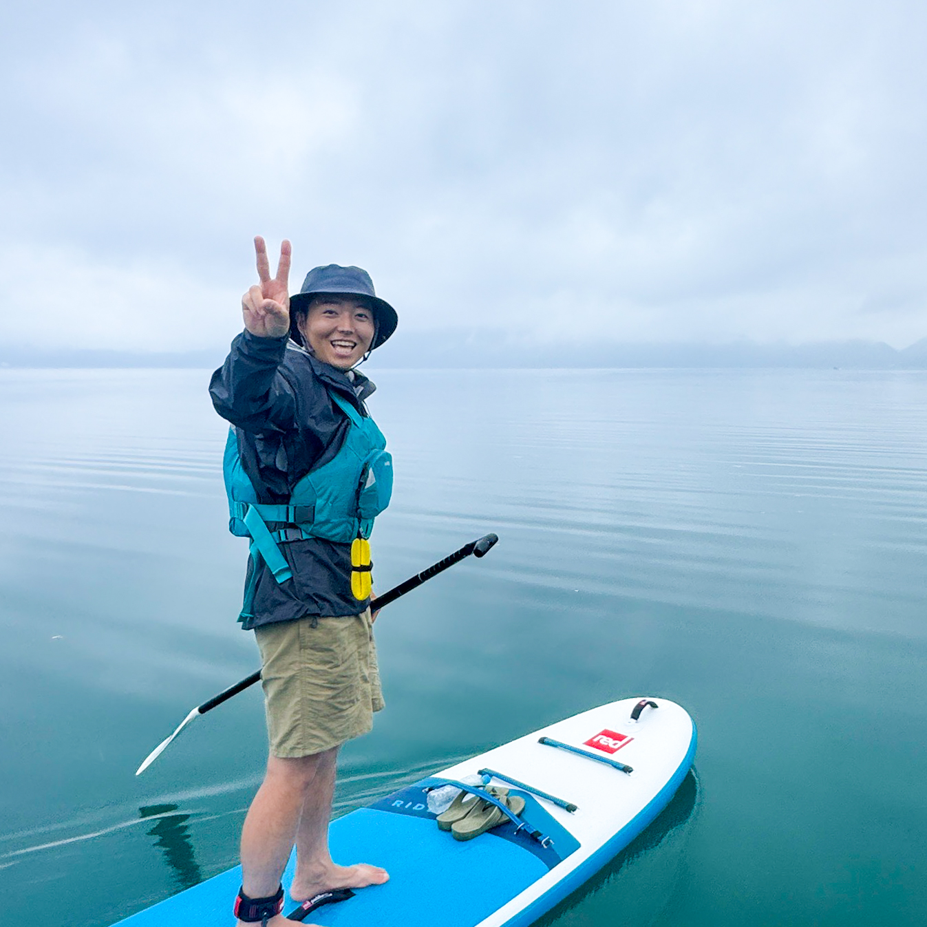 田沢湖でSUPボードに立つMikkeガイドの村上裕哉